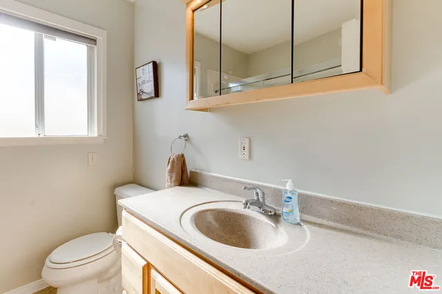 a bathroom with a toilet sink and mirror