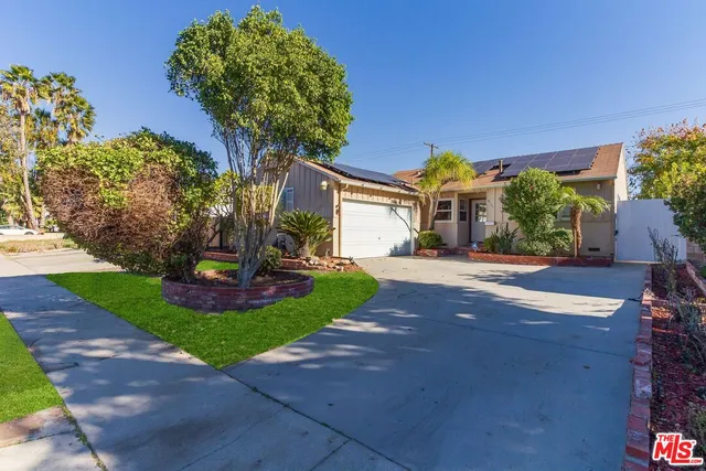 a front view of a house with a yard and outdoor seating