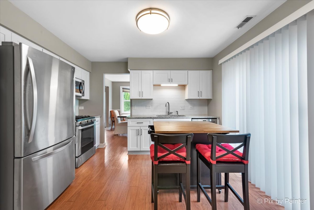 1025 Oswego Road Naperville, IL 60540 - Photo 11 of 42 a kitchen with granite countertop stainless steel appliances a sink and refrigerator