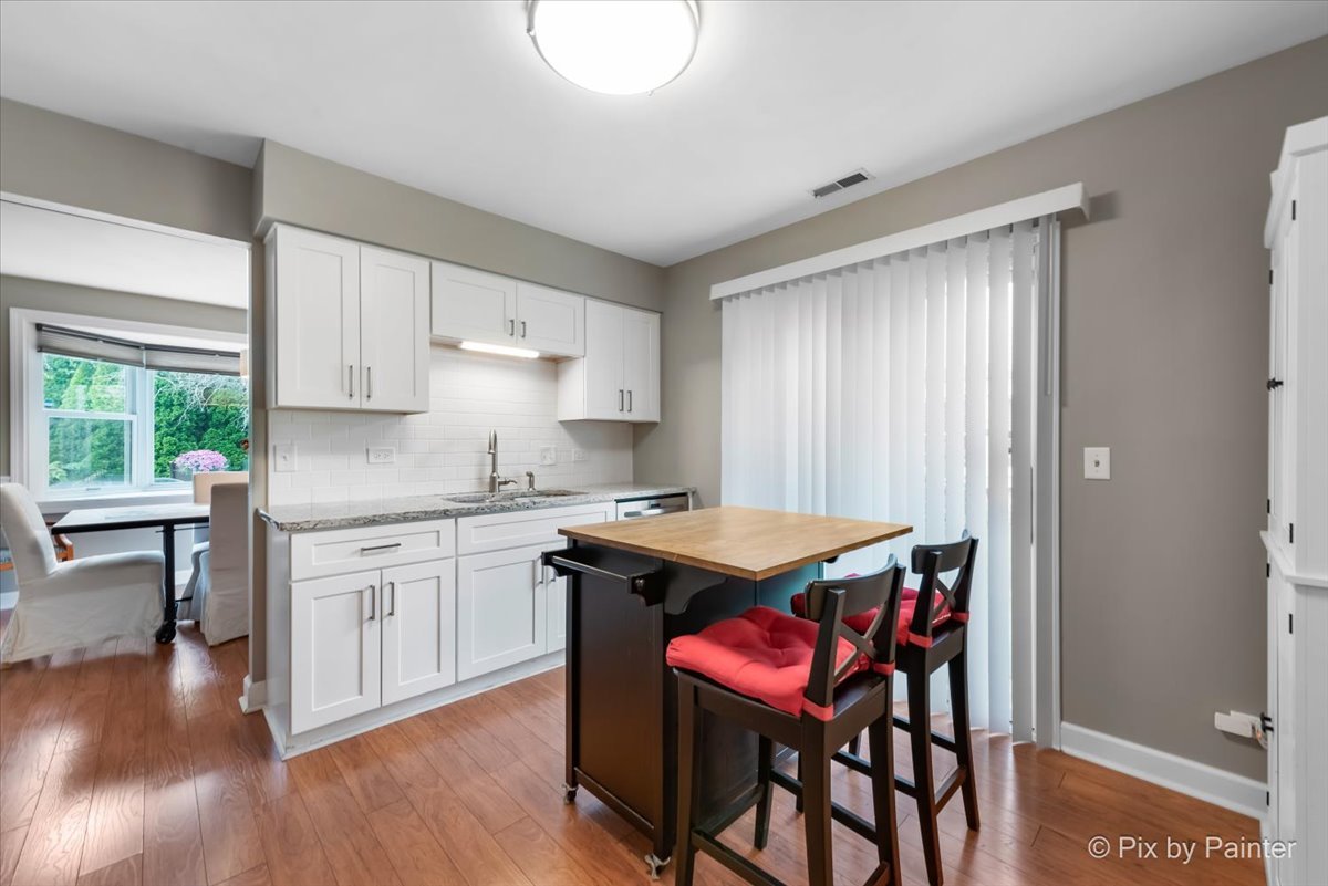 1025 Oswego Road Naperville, IL 60540 - Photo 12 of 42 a kitchen with a table chairs sink and cabinets