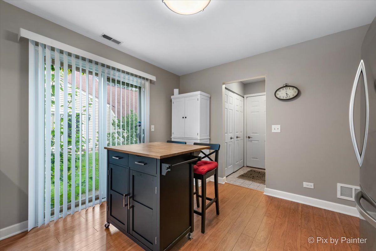 1025 Oswego Road Naperville, IL 60540 - Photo 13 of 42 a view of a kitchen with furniture and wooden floor