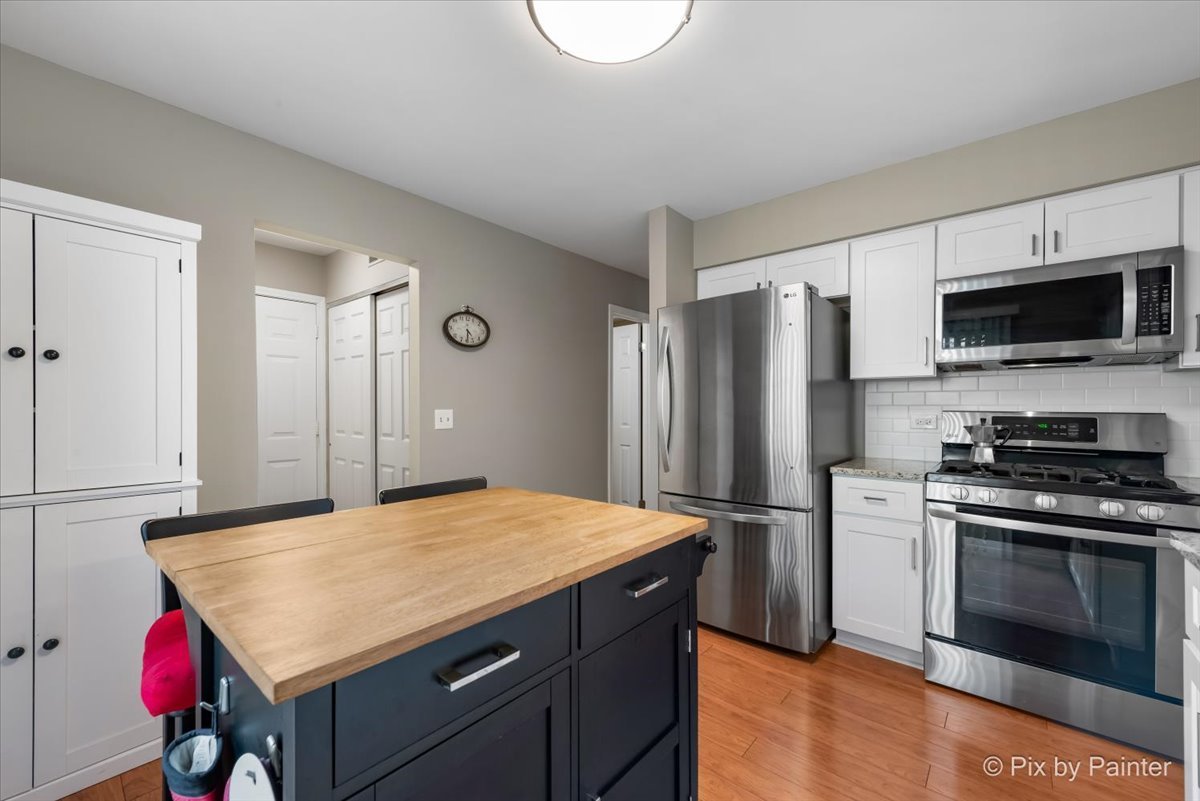 1025 Oswego Road Naperville, IL 60540 - Photo 14 of 42 a kitchen with a stove a refrigerator and a microwave