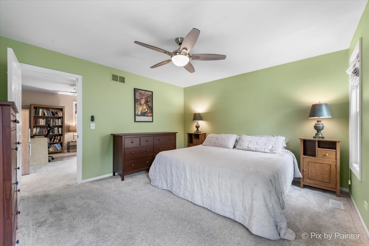 1025 Oswego Road Naperville, IL 60540 - Photo 17 of 42 a bedroom with a bed and a chandelier