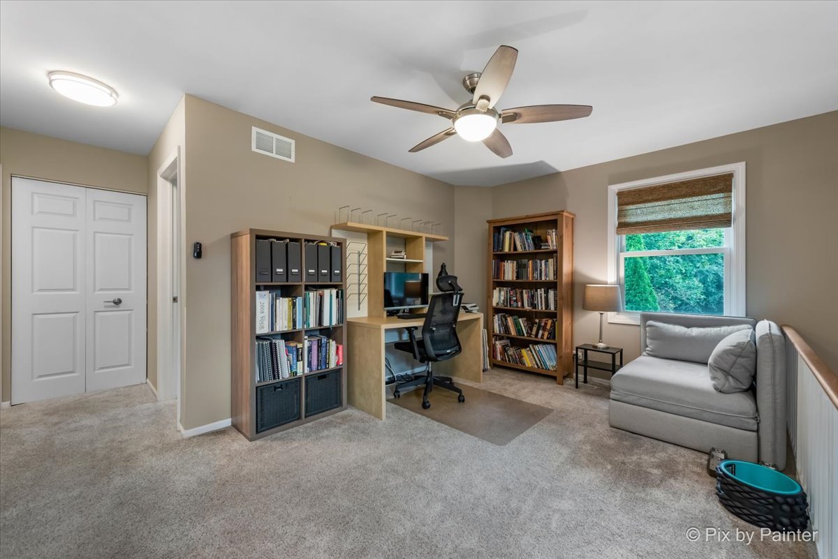 1025 Oswego Road Naperville, IL 60540 - Photo 24 of 42 a living room with furniture and a book shelf