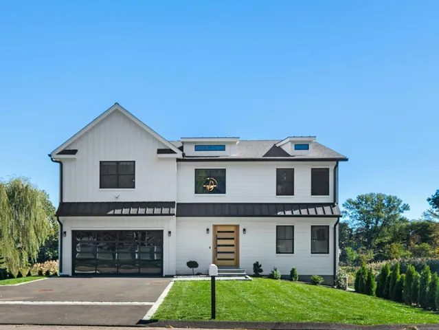 a front view of a house with a garden and garage