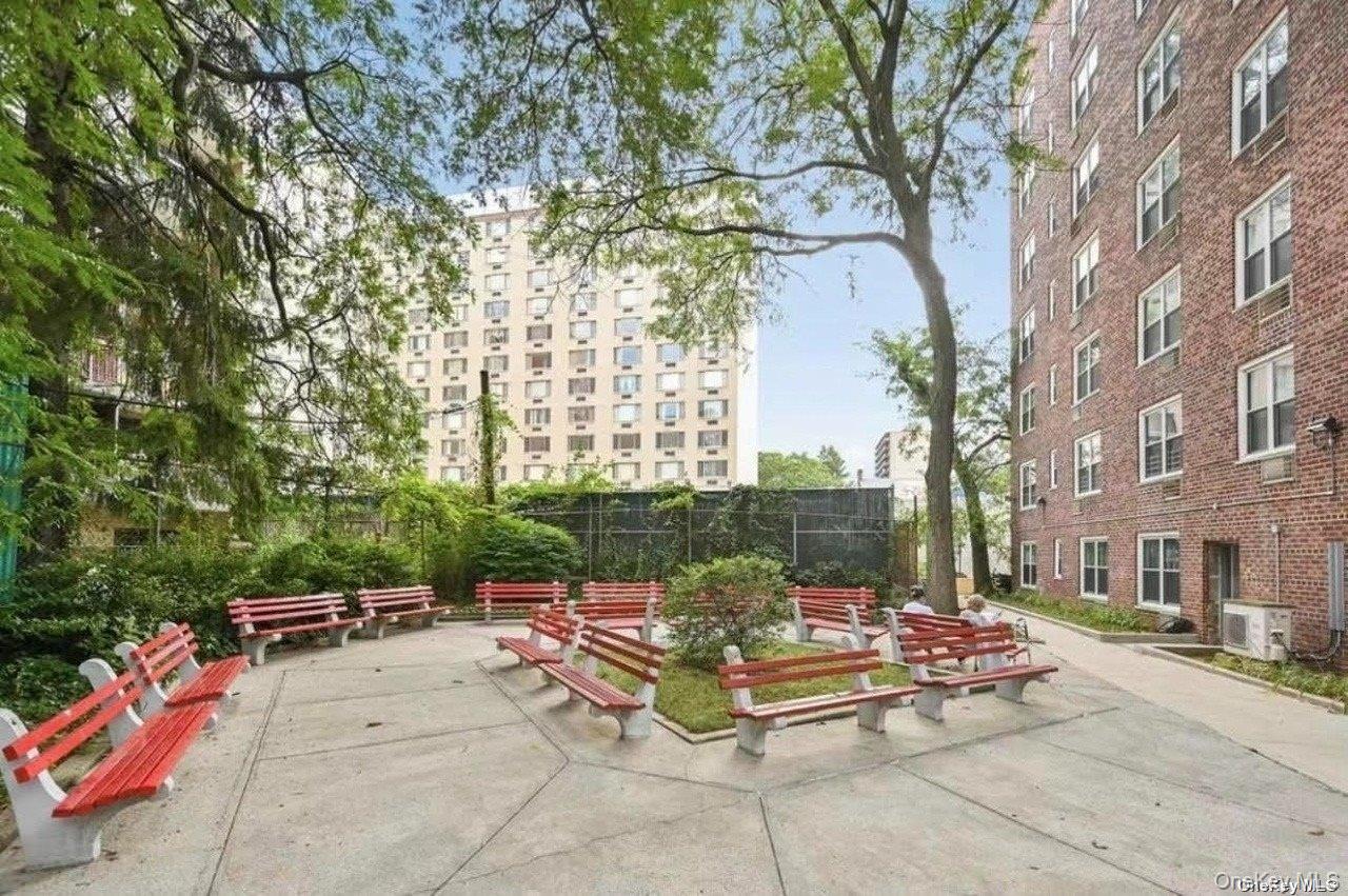 142-05 Roosevelt Avenue, Unit 521 Queens, NY 11354 - Photo 12 of 12 a view of a patio with couches and a fire pit and large trees