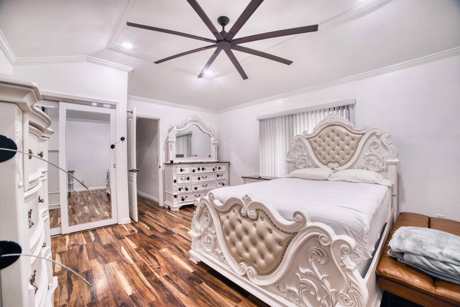 2520 Meadowrest Way Madera, CA 93637 - Photo 29 of 39 a bedroom with a large bed and a chandelier