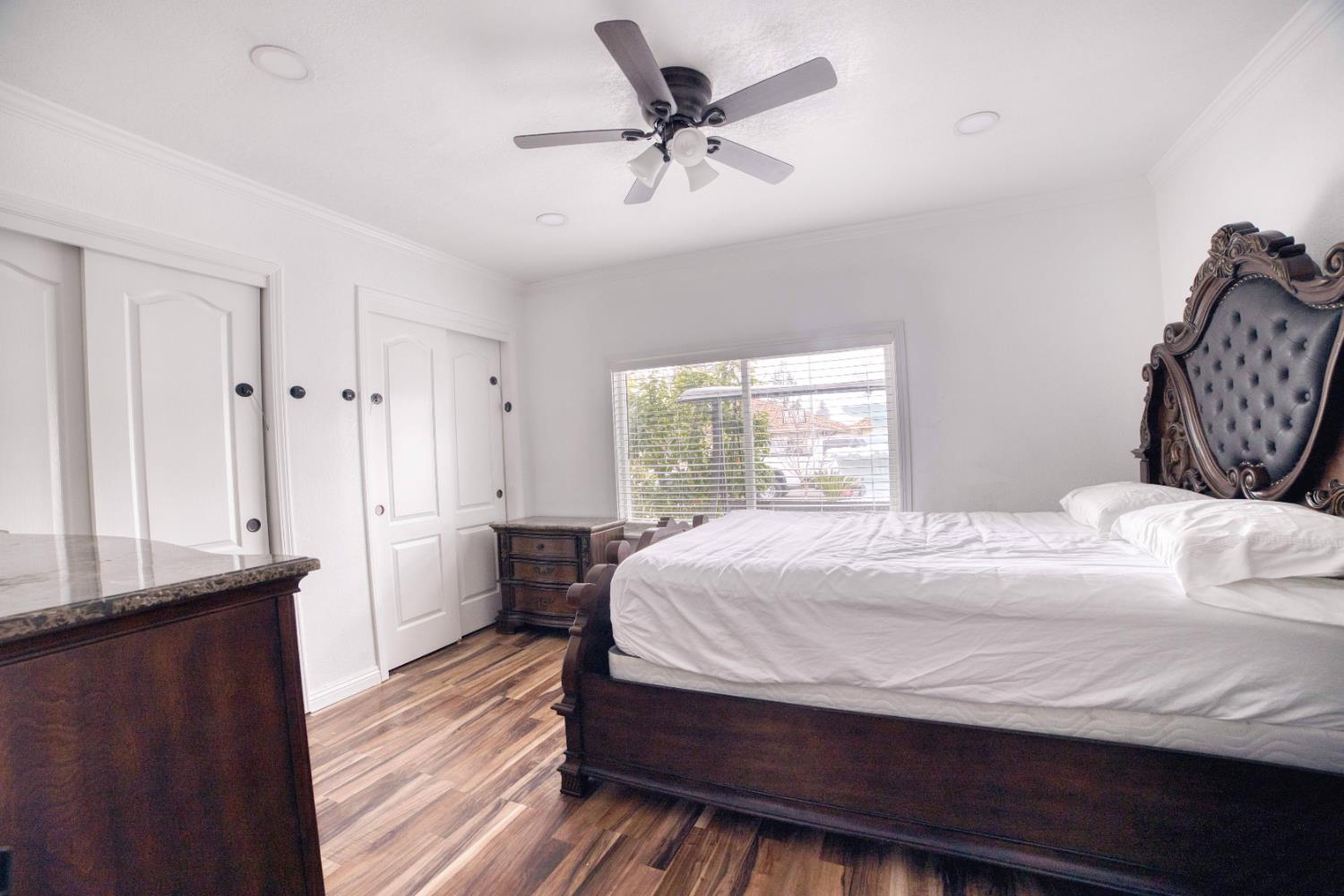 2520 Meadowrest Way Madera, CA 93637 - Photo 30 of 39 a bedroom with a bed and a chandelier