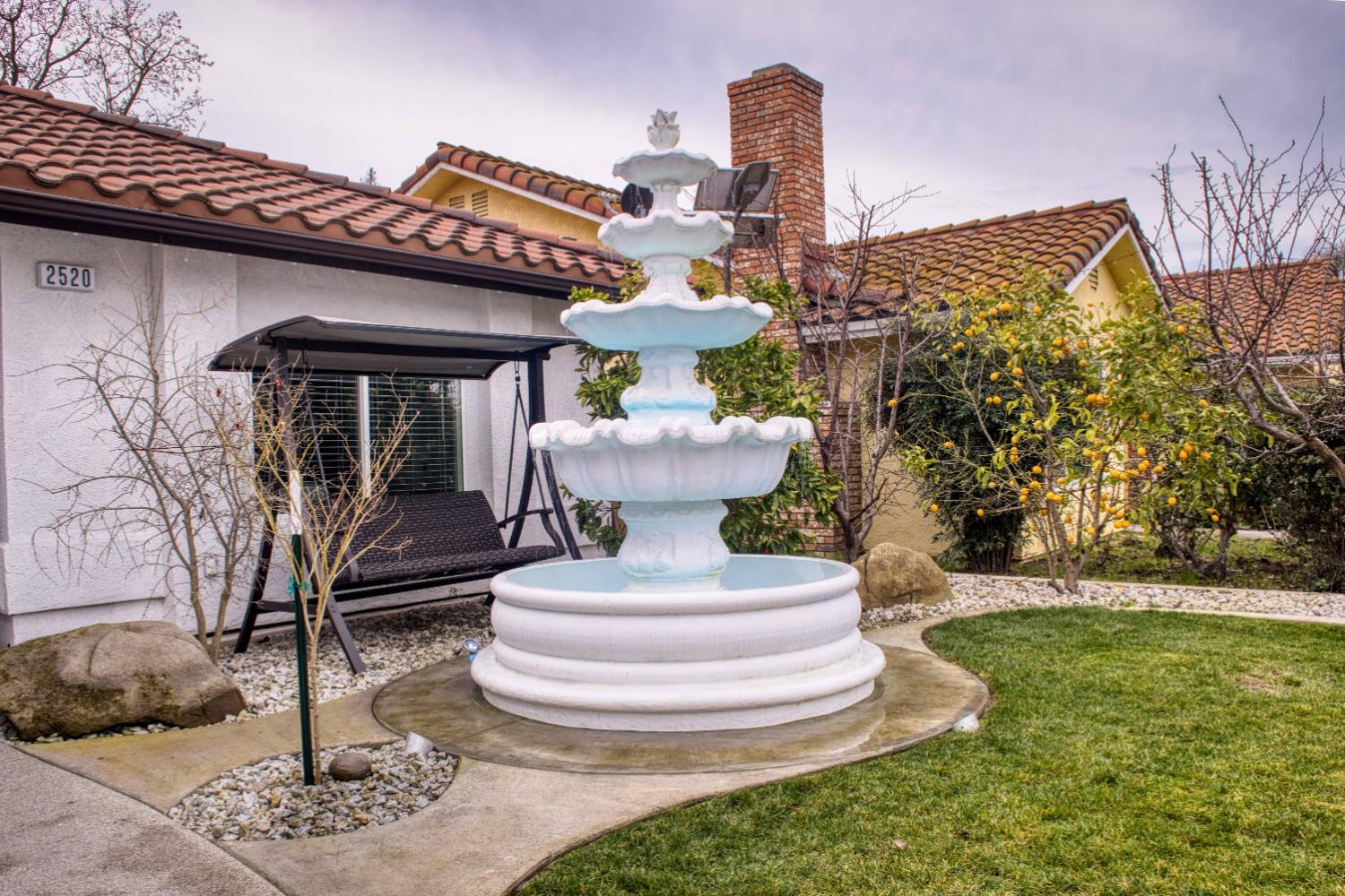 2520 Meadowrest Way Madera, CA 93637 - Photo 36 of 39 a view of a white house with a fountain and a fountain