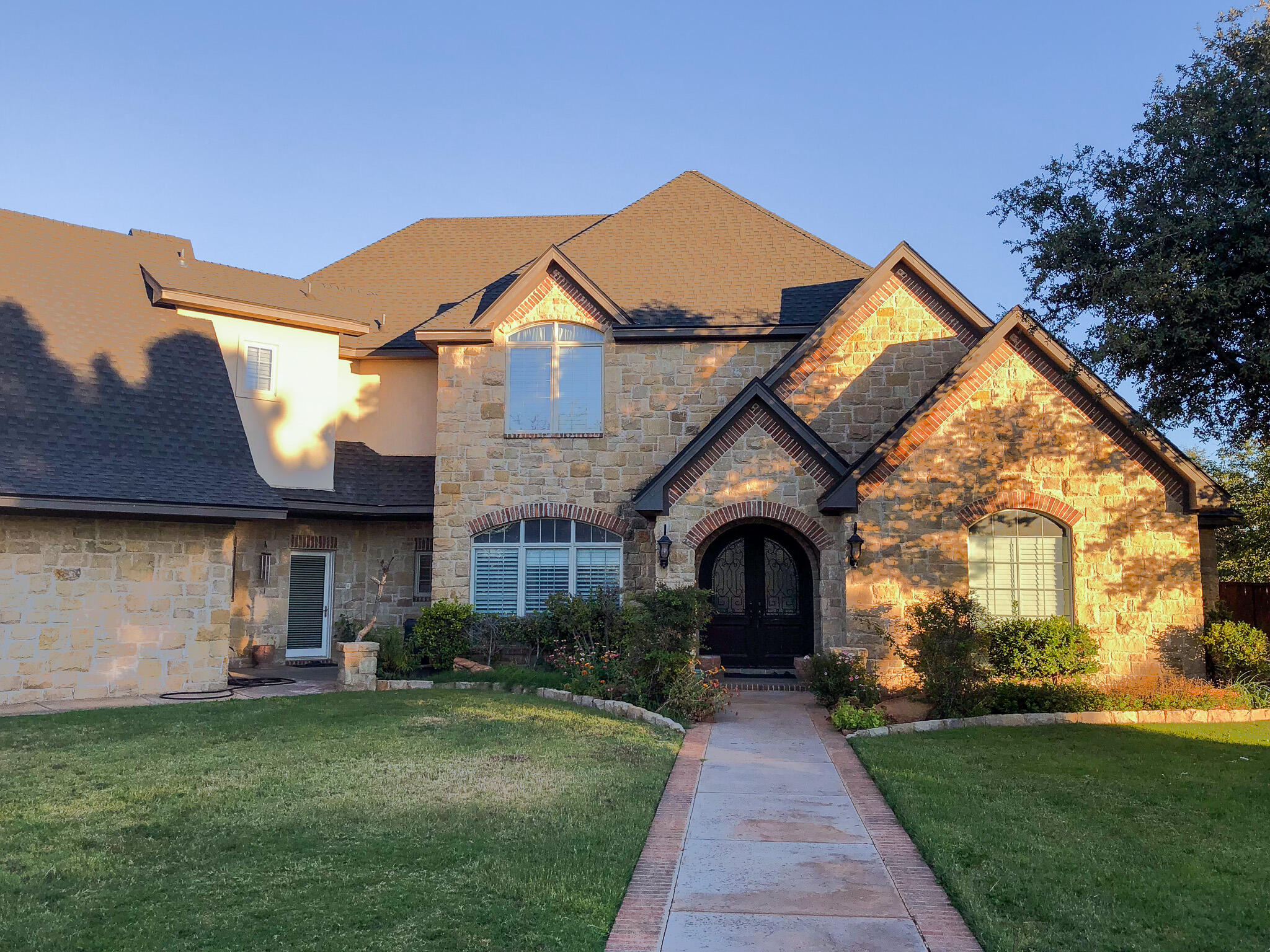 5502 156th Street Lubbock, TX 79424 - Photo 3 of 37 a front view of a house with a garden and yard