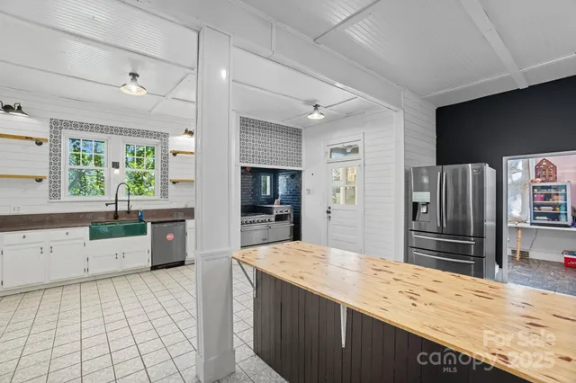 a kitchen with stainless steel appliances kitchen island granite countertop a refrigerator and a sink
