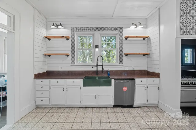 a kitchen with white cabinets a sink and a window