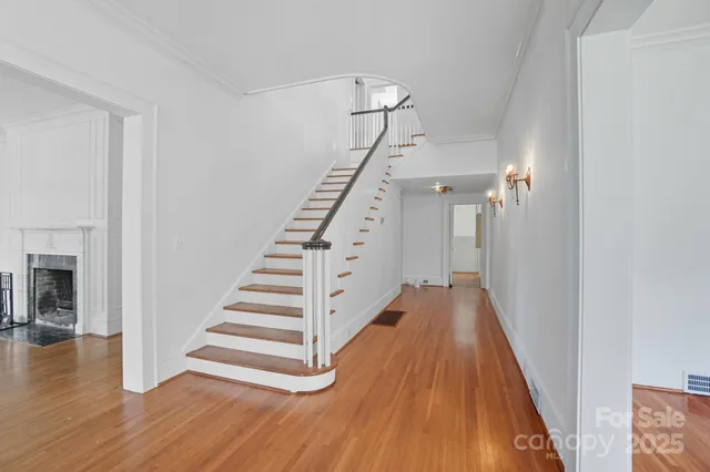 a view of a hallway with wooden floor and staircase