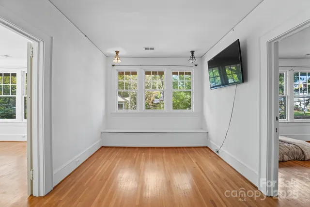 a view of hallway with a large window and wooden floor