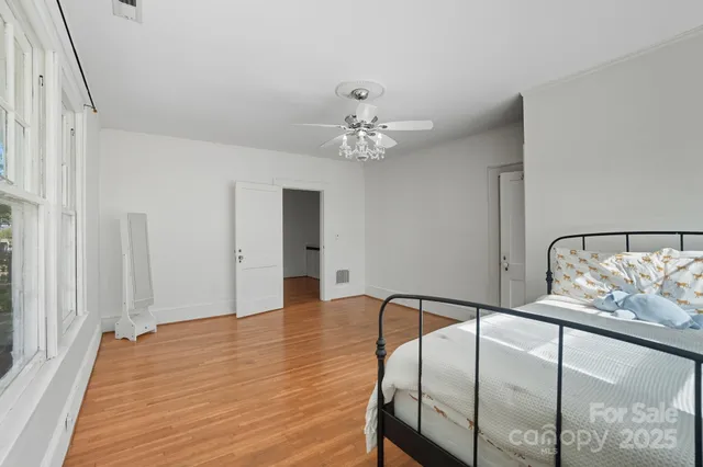 a view of a bedroom with wooden floor