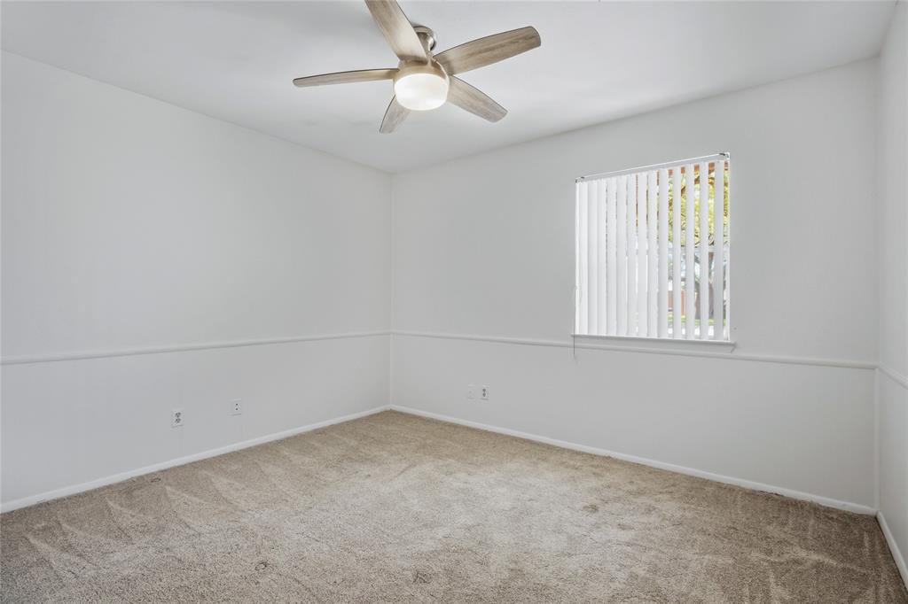 15721 Mapleview Circle Dallas, TX 75248 - Photo 18 of 40 an empty room with a window and ceiling fan