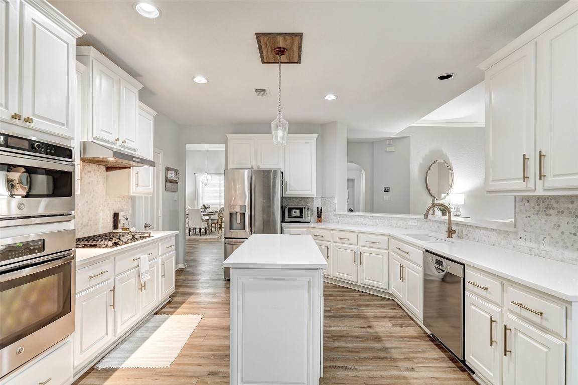 Your new home with updated kitchen features an uninterrupted prep island with cabinets below & Quartz countertops w/ penny marble backsplash.