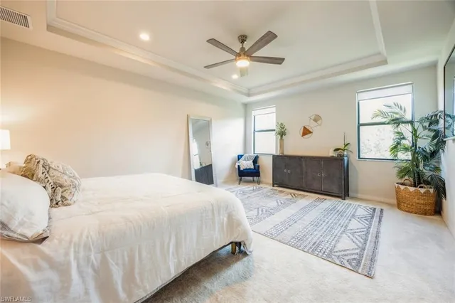 a spacious bedroom with a large bed and a chandelier
