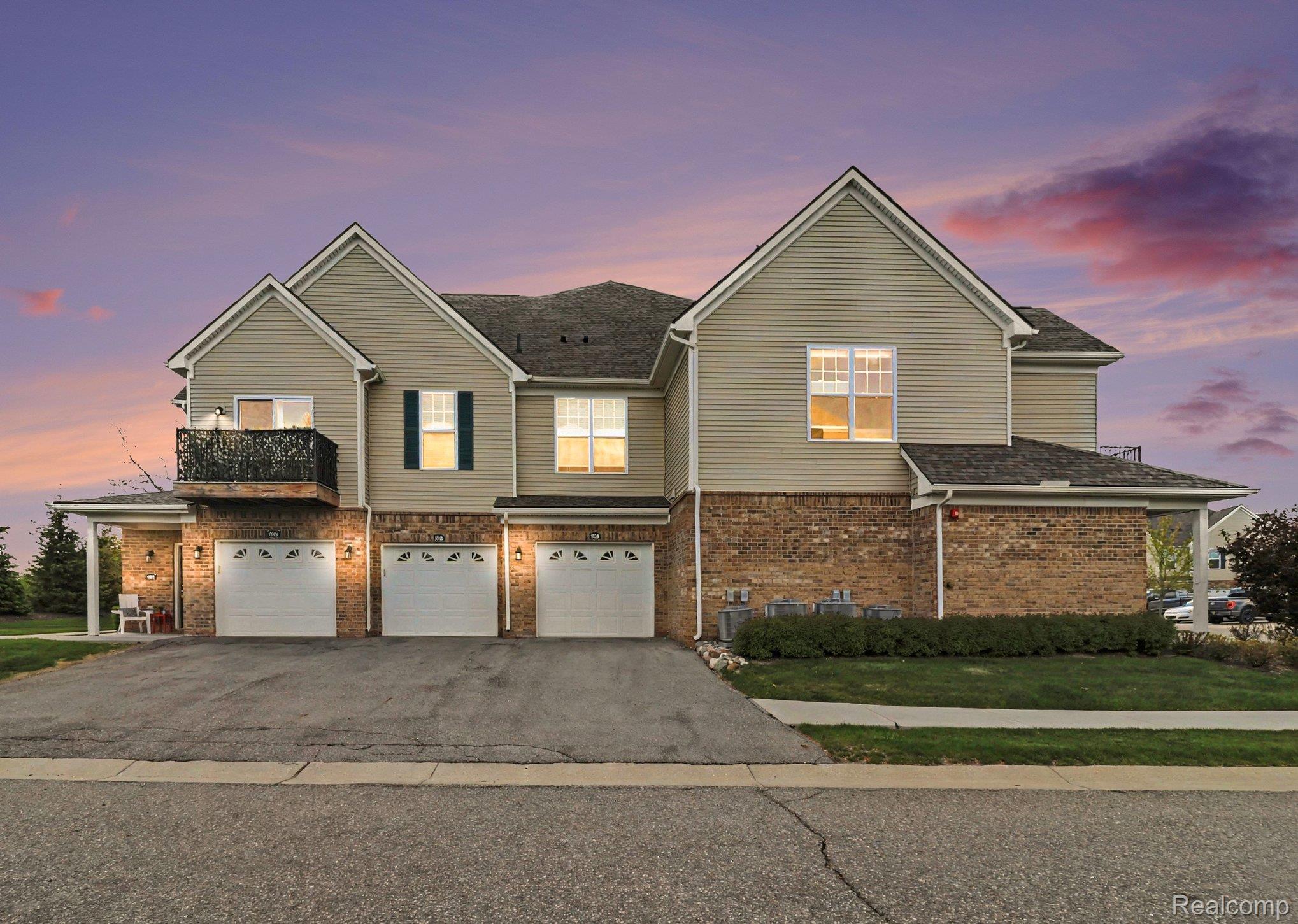 9864 Ridge Run Street Howell, MI 48855 - Photo 1 of 23 Traditional-style home featuring driveway, an attached garage, brick siding, and a shingled roof