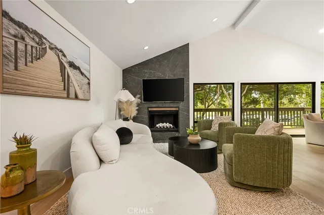 a living room with furniture a fireplace and a floor to ceiling window
