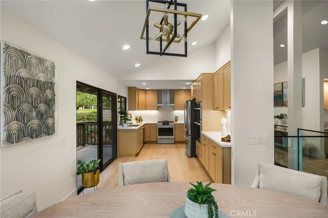 a living room with furniture kitchen view and a chandelier