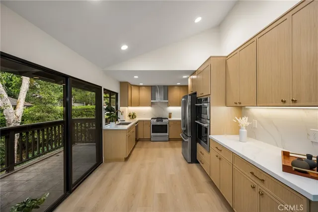 a kitchen with stainless steel appliances granite countertop a refrigerator a sink a stove and island