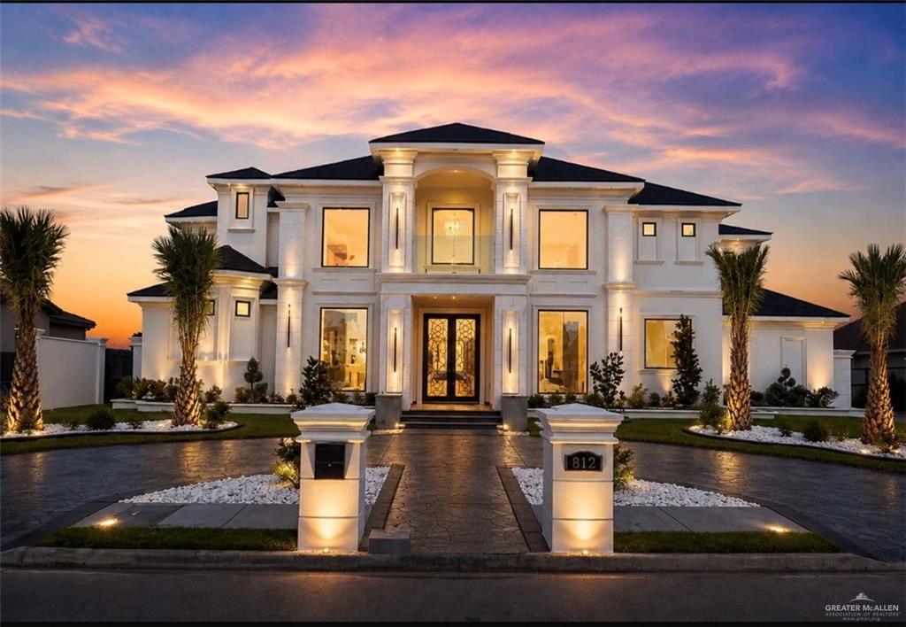 Modern architectural residence featuring a grand portico entry, expansive windows, and a black tile roof