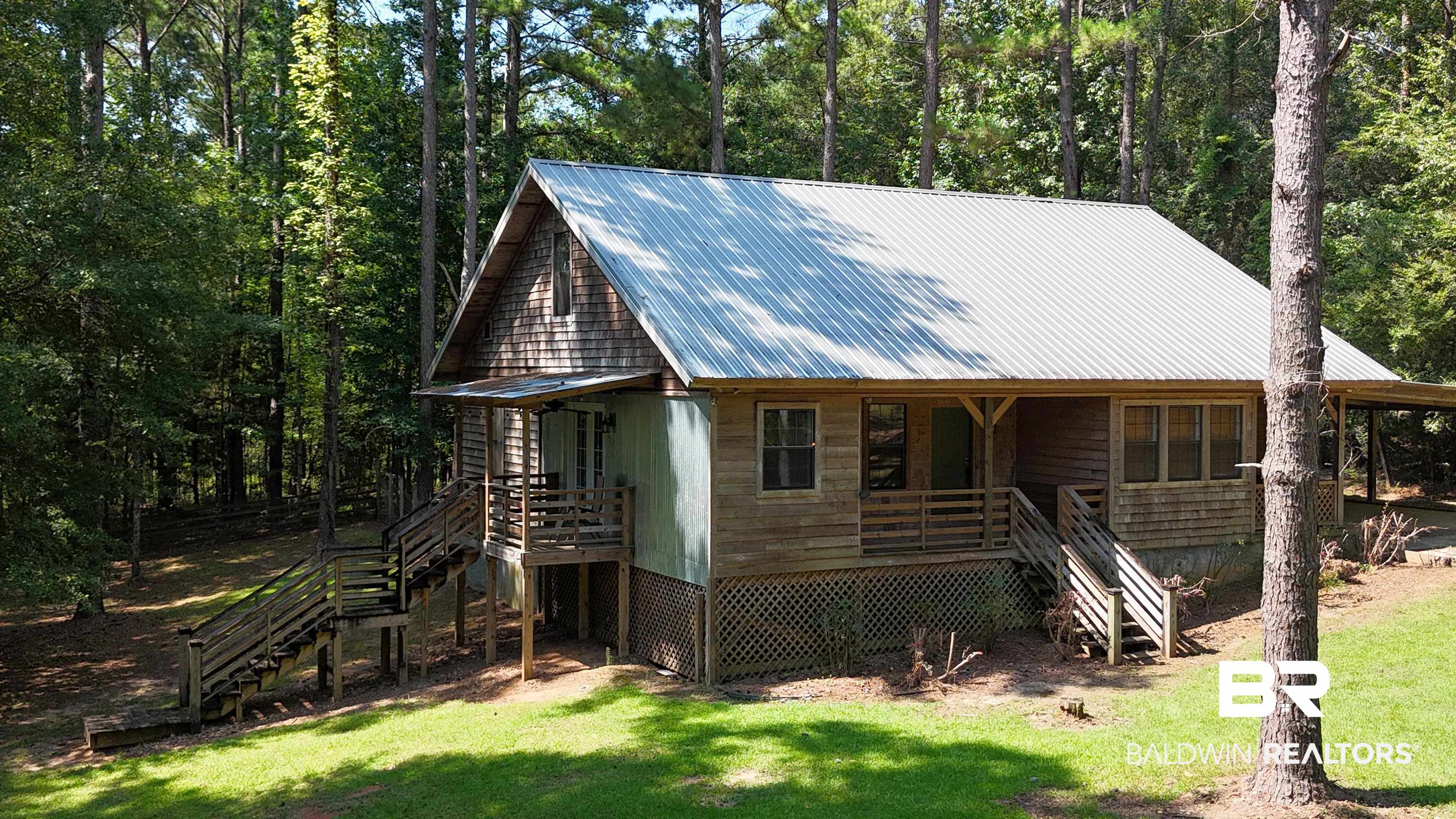 102 Brown Road Evergreen, AL 36401 - Photo 24 of 26 Rustic home with stairway, a front lawn, a metal roof, and covered porch