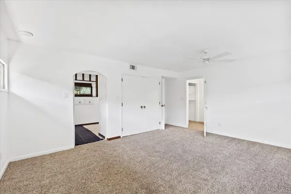 a view of an empty room with a window and brick walls