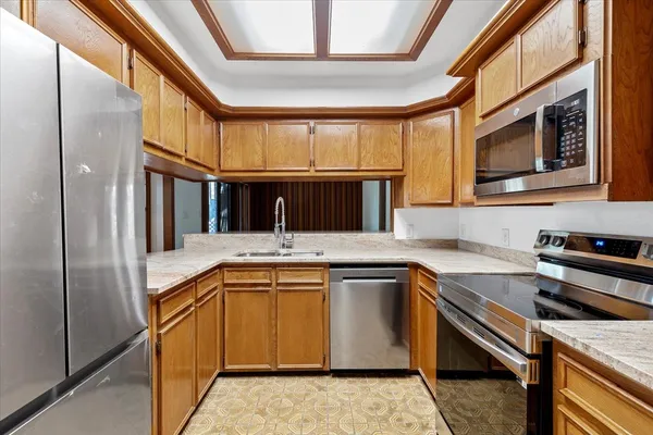a kitchen with granite countertop cabinets stainless steel appliances and a sink