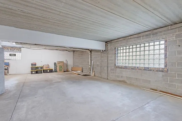 a utility room with stainless steel appliances white cabinets and a sink