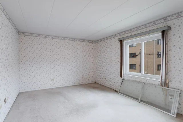 a view of an empty room with a fireplace and a window