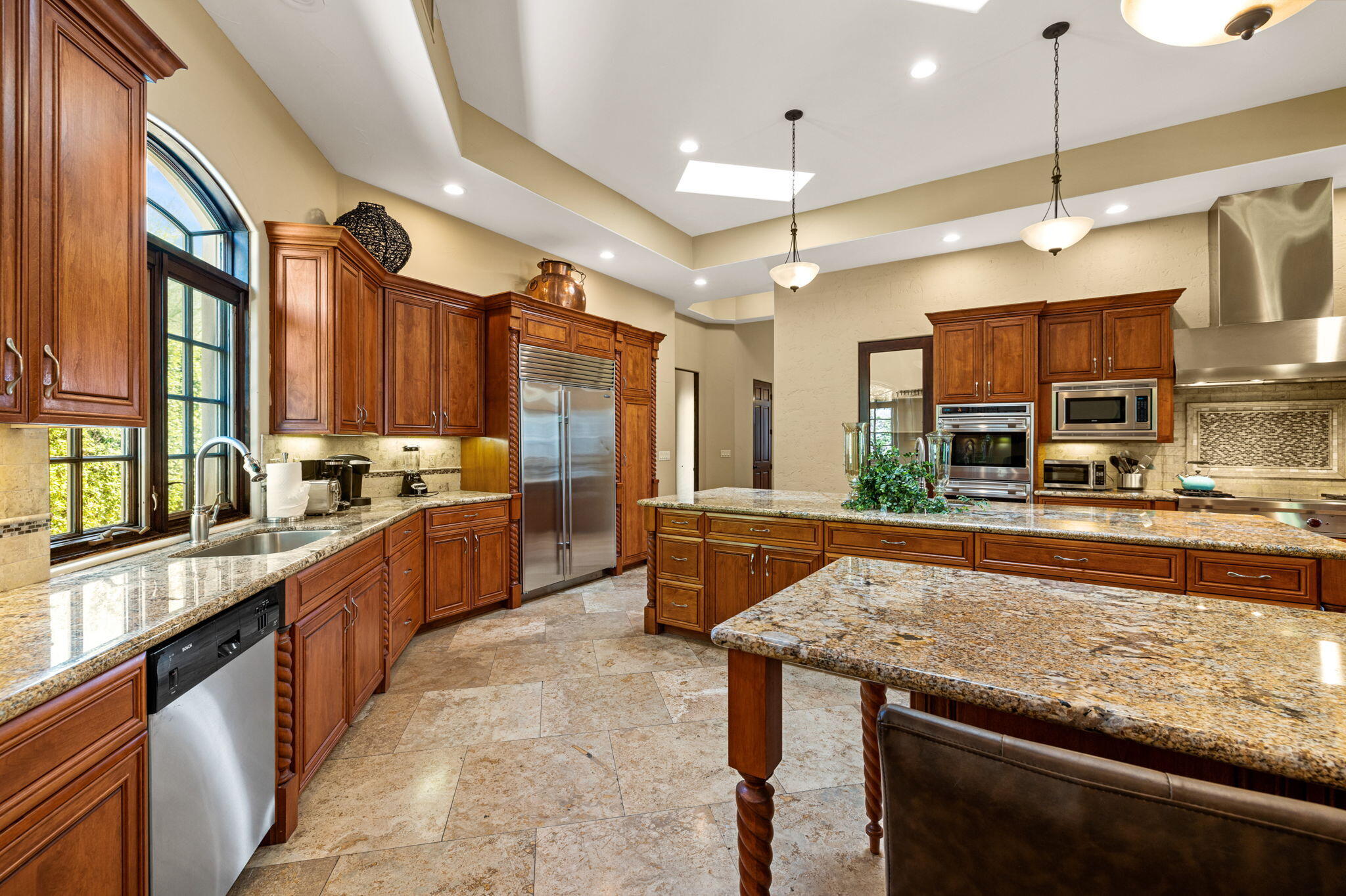 72033 Clancy Lane Rancho Mirage, CA 92270 - Photo 32 of 83 a large kitchen with stainless steel appliances kitchen island granite countertop a large stove a sink dishwasher and cabinets with wooden floor