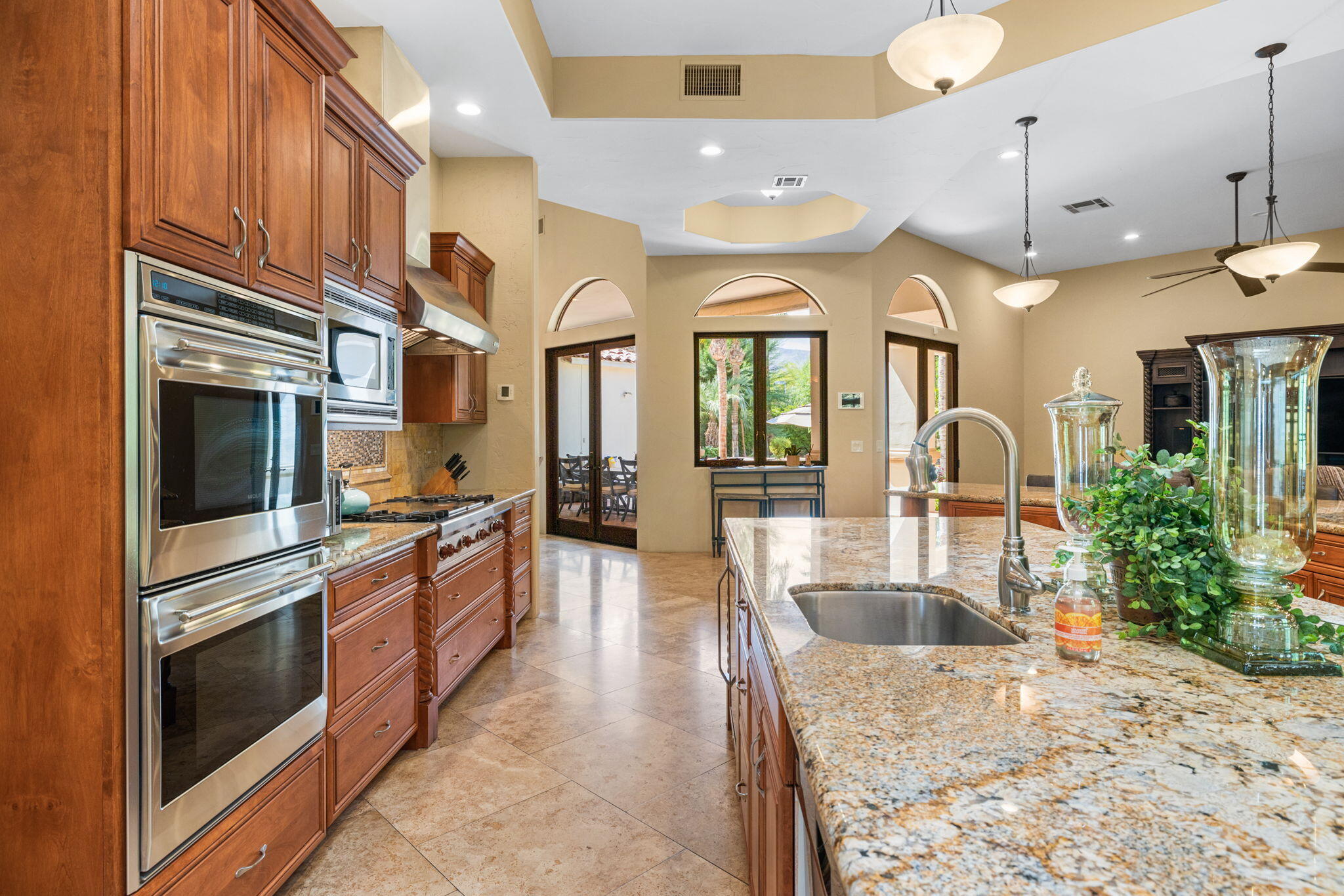 72033 Clancy Lane Rancho Mirage, CA 92270 - Photo 34 of 83 a kitchen with stainless steel appliances kitchen island granite countertop a stove and cabinets