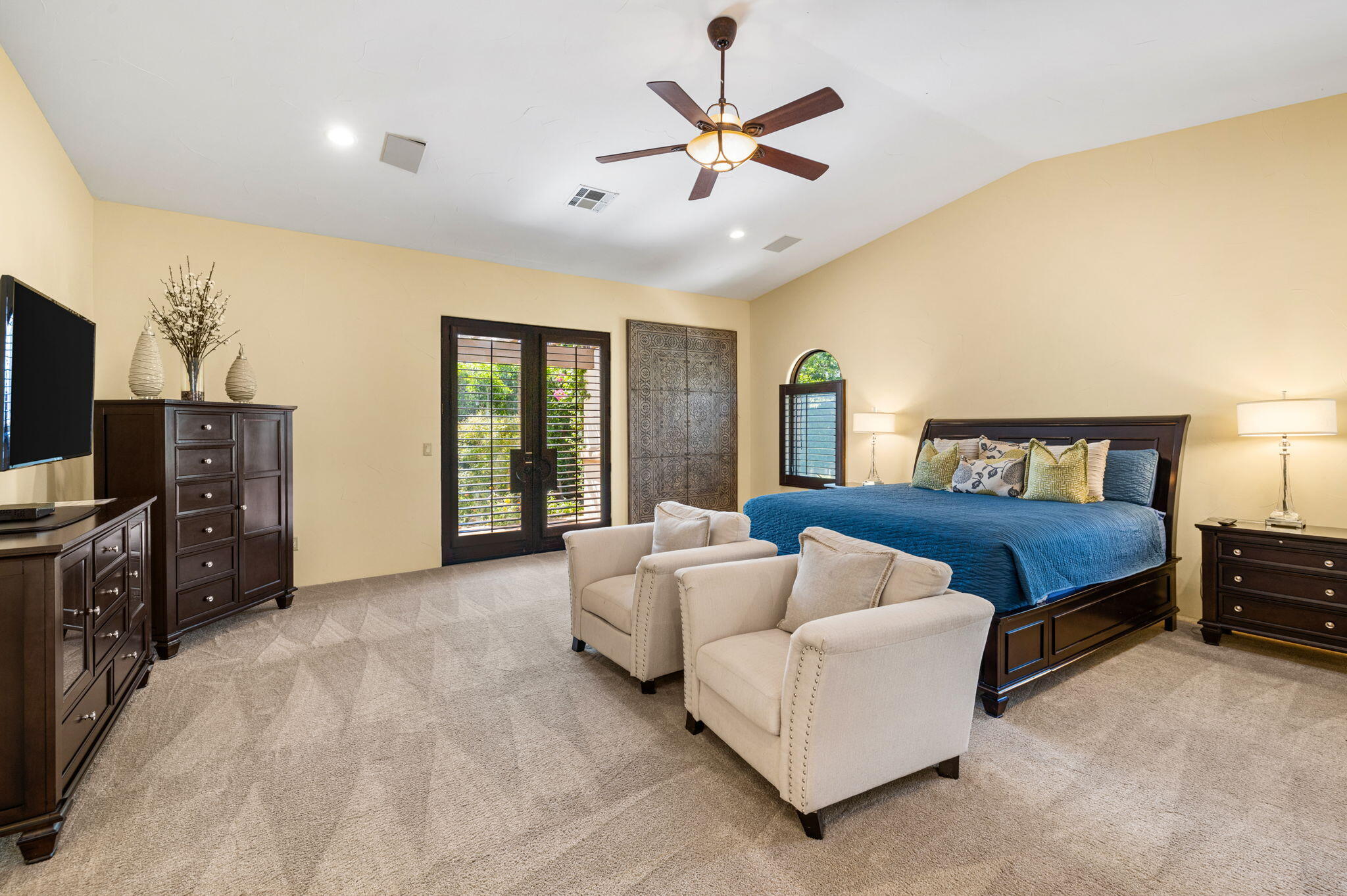 72033 Clancy Lane Rancho Mirage, CA 92270 - Photo 44 of 83 a spacious bedroom with a bed a dresser and a flat screen tv
