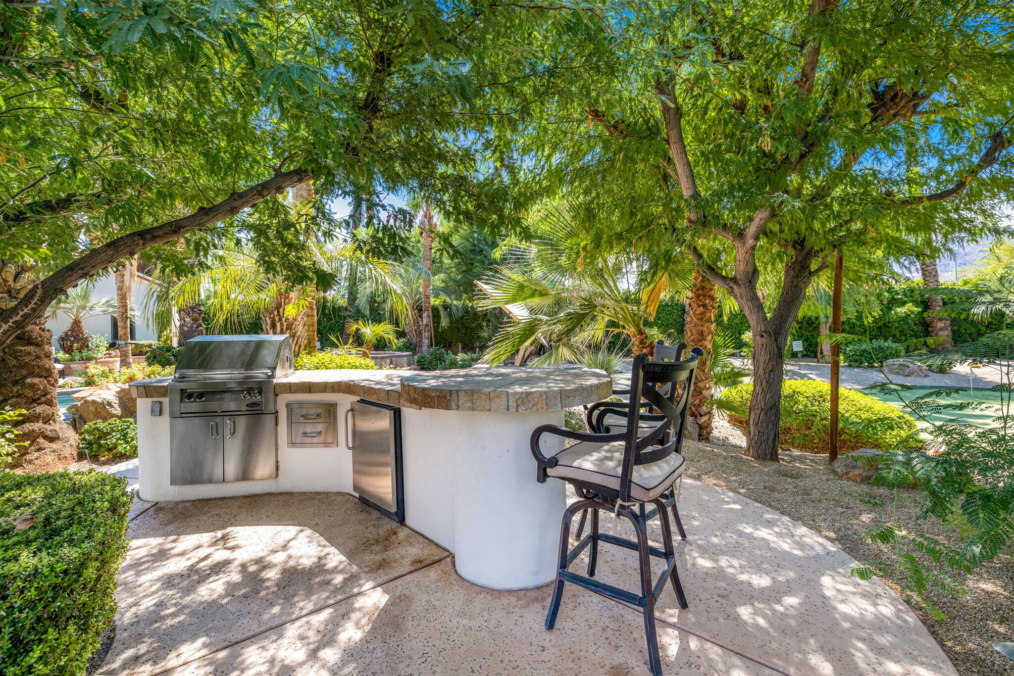 72033 Clancy Lane Rancho Mirage, CA 92270 - Photo 68 of 83 a view of a patio with table and chairs potted plants and large tree