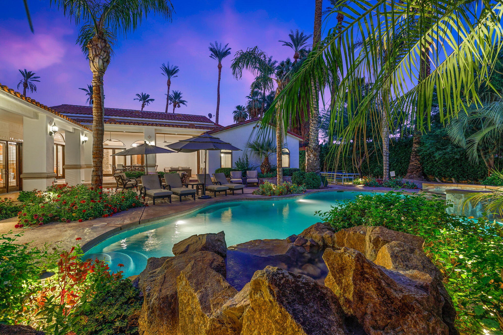 72033 Clancy Lane Rancho Mirage, CA 92270 - Photo 7 of 83 a view of a swimming pool with a table and chairs