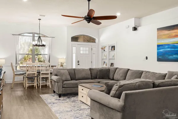 a living room with furniture a ceiling fan and a window