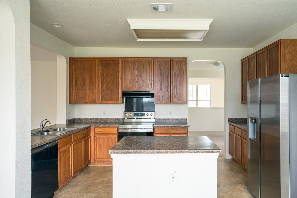 612 Dark Tree Lane Round Rock, TX 78664 - Photo 13 of 40 a kitchen with stainless steel appliances granite countertop a sink stove and refrigerator
