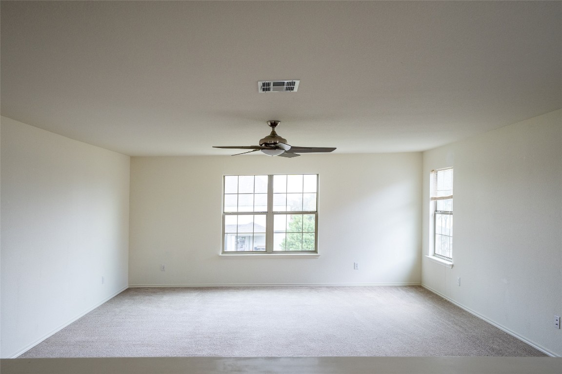 612 Dark Tree Lane Round Rock, TX 78664 - Photo 19 of 40 an empty room with windows and ceiling fan