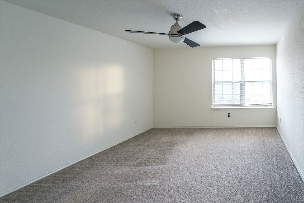 612 Dark Tree Lane Round Rock, TX 78664 - Photo 23 of 40 an empty room with a window and a ceiling fan