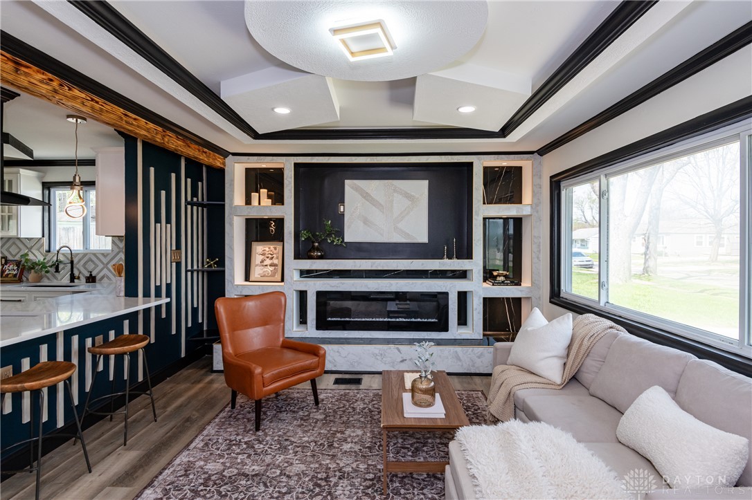 5240 Haverfield Road Dayton, OH 45432 - Photo 5 of 58 This inviting living space features an elegant fireplace, an open-concept layout, and warm wood flooring.