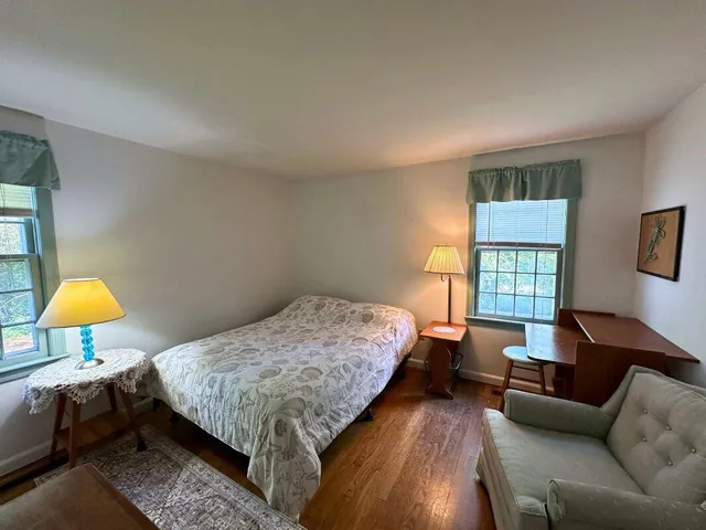 a bedroom with a bed couch and a window