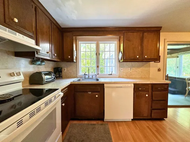 a kitchen with stainless steel appliances granite countertop wooden cabinets a sink and a stove