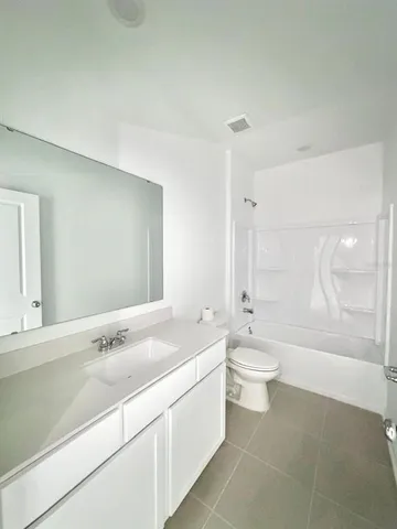 a bathroom with a double vanity sink toilet mirror and bathtub