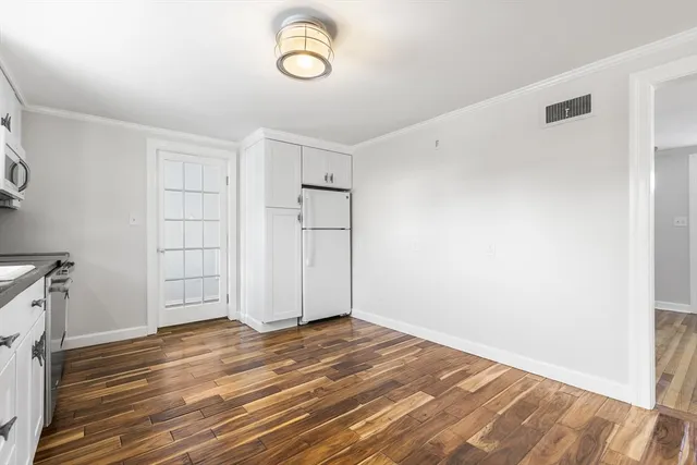 a kitchen with granite countertop a refrigerator and a stove top oven