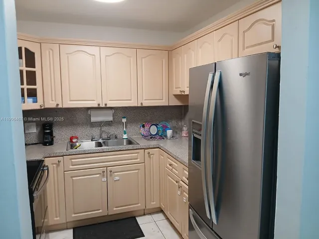 a kitchen with stainless steel appliances granite countertop a refrigerator sink and cabinets