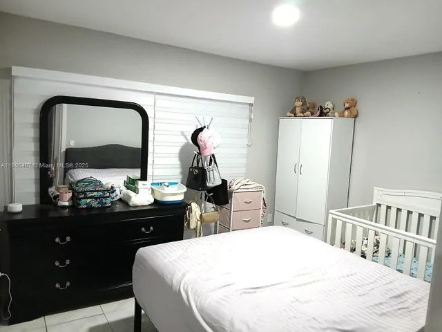 a bedroom with a bed and a large mirror on dresser