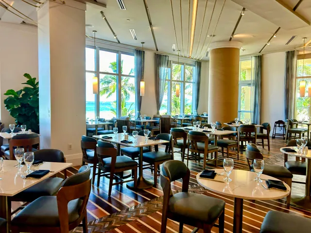 a view of a patio with table and chairs potted plants and palm tree