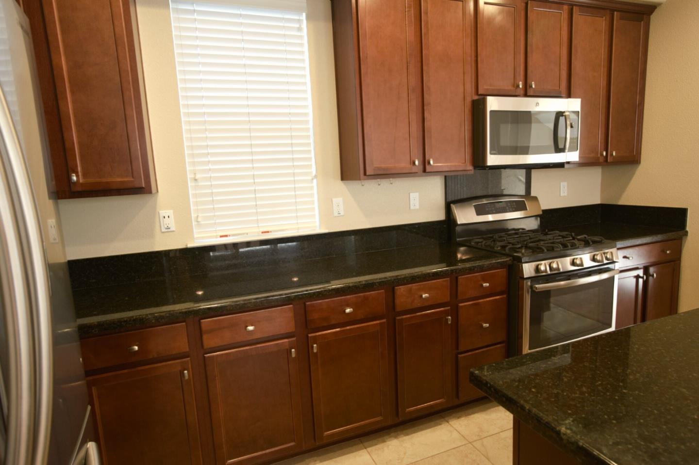1579 Canal Street Milpitas, CA 95035 - Photo 11 of 36 a kitchen with granite countertop a sink a stove and cabinets